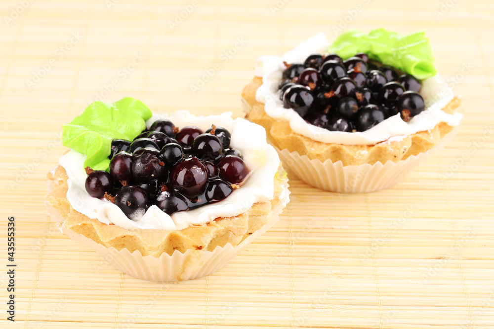 sweet cakes with berries on bamboo mat