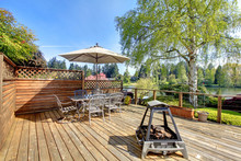 Large Deck With Furniture And Umbrella With Lake View.