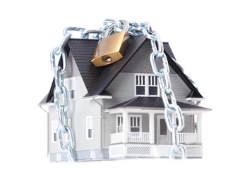 Real estate concept - chain with lock around the house model