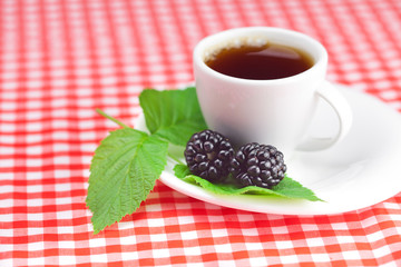 Wall Mural - cup of tea and  blackberry with leaves on plaid fabric