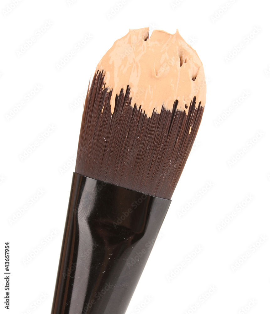 Cosmetic liquid foundation and brush isolated on white