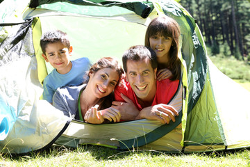 Wall Mural - Portrait of family laying in camp tent