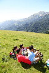 Wall Mural - Family laying down the grass enjoying mountain view