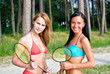 © M-Production - Two girls posing with badminton rackets on the beach
