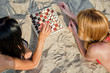© M-Production - Two girls playing chess on the beach