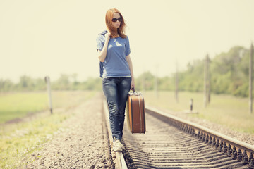 Wall Mural - Young fashion girl with suitcase at railways.