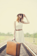 Wall Mural - Young fashion girl with suitcase at railways.