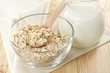Oat flaks on a glass bowl and jug of milk