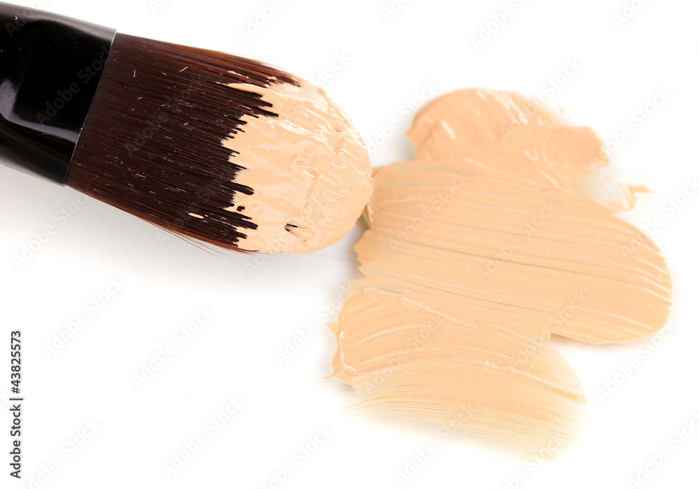 Cosmetic liquid foundation and brush isolated on white