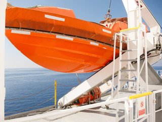 Orange lifeboat on deck of cruise ship