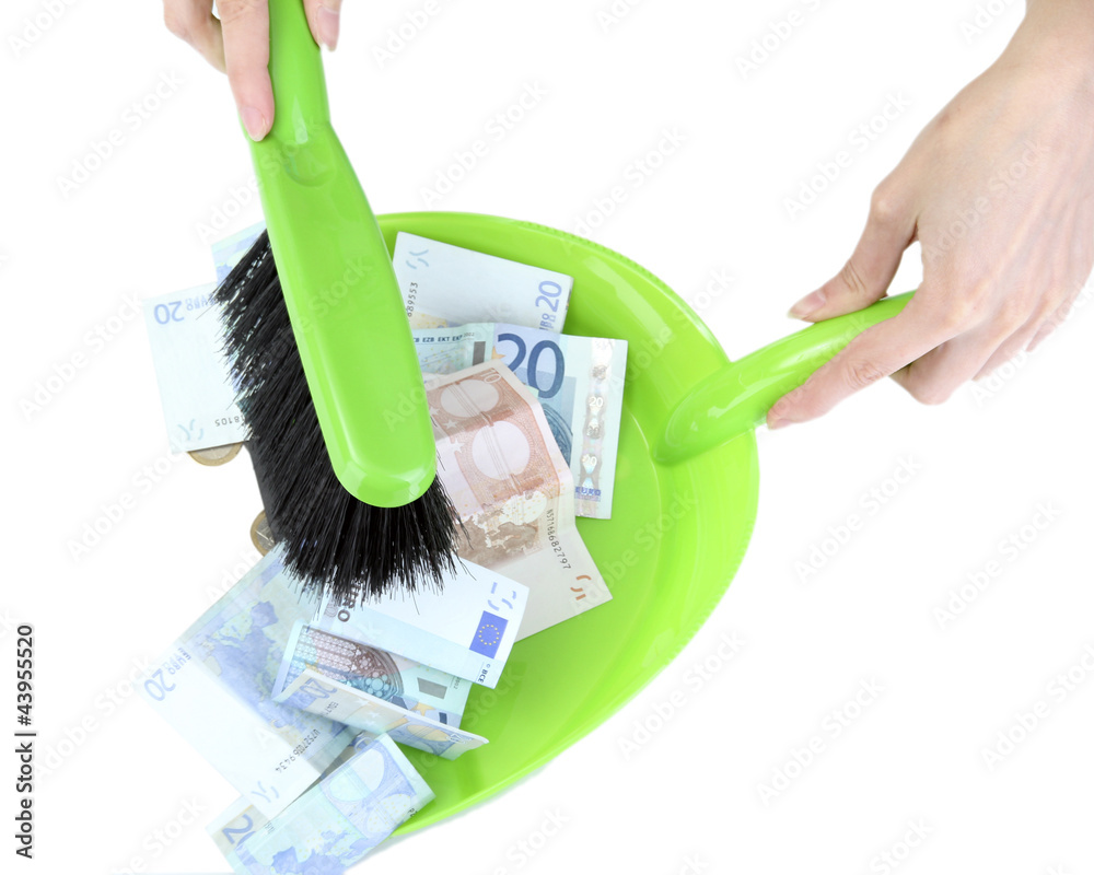 Sweeps money in the shovel on white background close-up