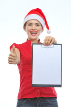 Happy Young Woman In Christmas Hat Showing Blank Clipboard And T