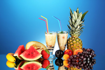 Wall Mural - Milk shakes with fruit on blue background close-up