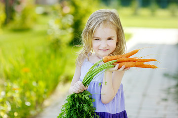 Wall Mural - Adorable little girl with carrots