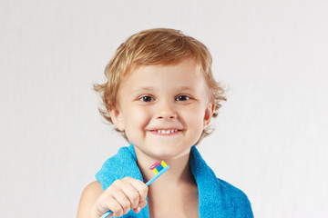 Young cute blond boy with toothbrush with pink toothpaste