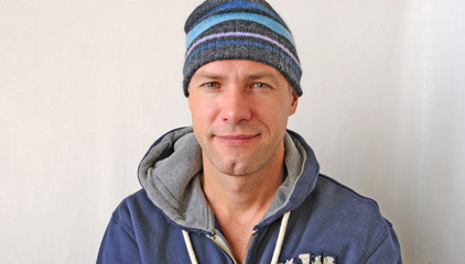 Wall Mural - Portrait of the smiling man wearing a knitted hat