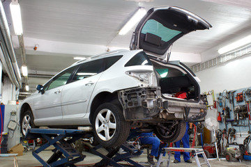 Car is lifted in car body repair service