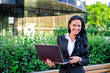 © M-Production - Businesswoman with notebook in city park