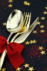 Christmas cutlery. Spoon, fork and knife on a starry background