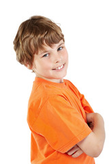 Smiling boy in orange t-shirt with folded arms stands