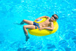© borissos - Boy floating on an inflatable circle in the pool.