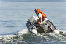 Man Riding In An Inflatable Boat With A Motor On Sea