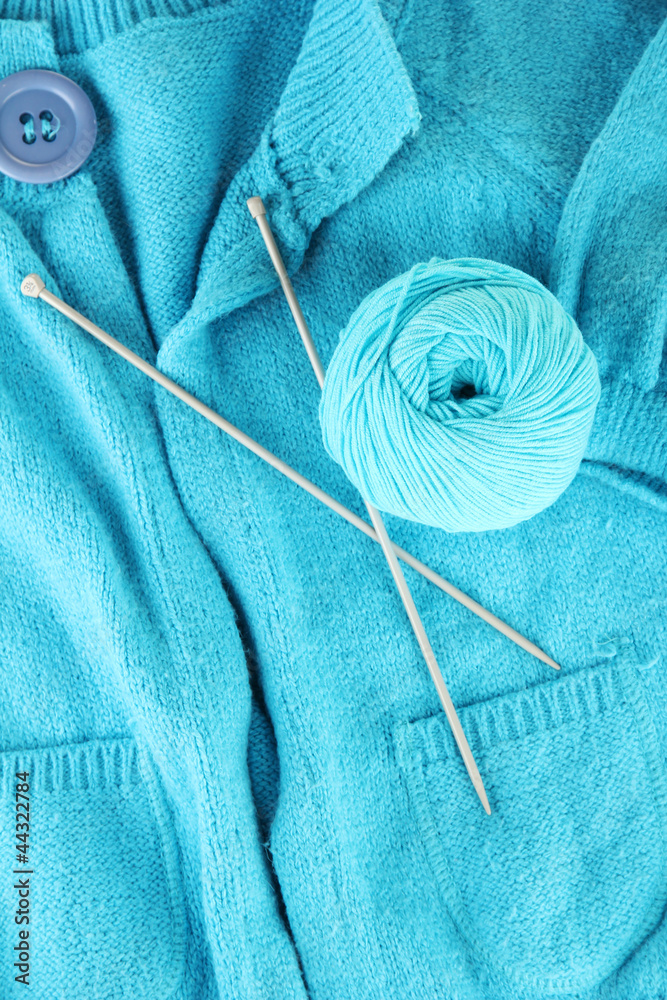 Blue sweater and a ball of wool close-up