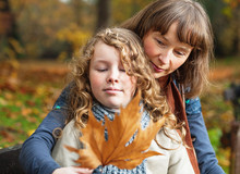 Mother And Daughter In An Autumn Park