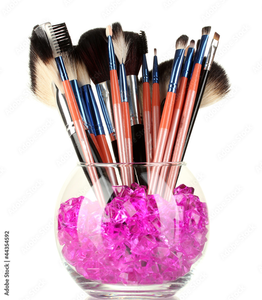 Make-up brushes in a bowl with stones isolated on white