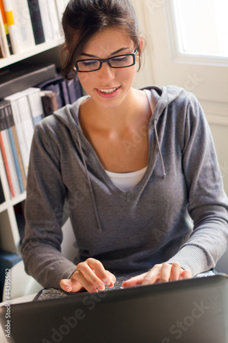 Fotografie, Obraz young beautiful woman working at home with a laptop
