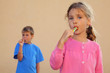 © Pavel Losevsky - Girl and boy suck multicolored candies. Sister looks at camera
