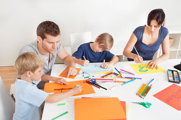 Young family drawing with colorful pencils