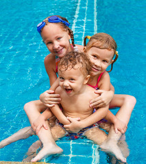 Canvas Print - two little girls and little boy playing in the pool