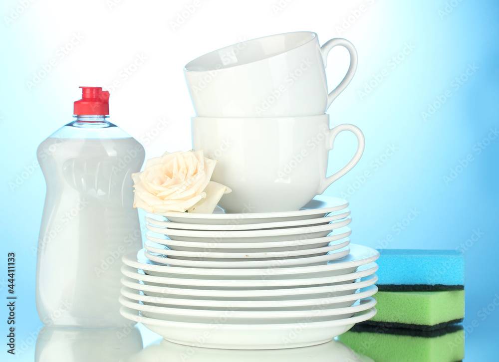 empty clean plates and cups with dishwashing liquid and sponges
