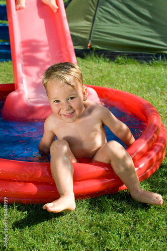 Kleiner Junge Mit Wasserrutsche Im Garten Buy This Stock Photo