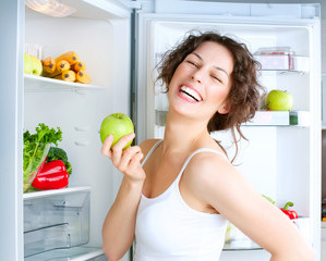 Wall Mural - Beautiful Young Woman near the Refrigerator with fresh apple