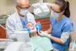 © CandyBox Images - Dentist with nurse doing procedure on patient