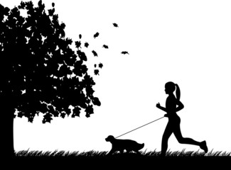 Girl running a dog in park in autumn or fall silhouette