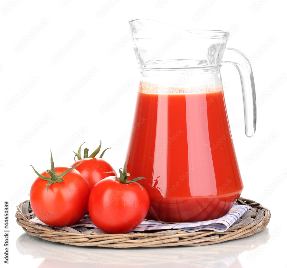 Tomato juice in pitcher on wicker mat isolated on white