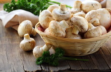 Fresh Champignon Mushrooms In A Wicker Basket