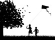 Silhouette of running boys with flying kite in autumn or fall