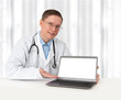 © spaxiax - young doctor in lab coat with laptop