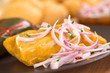 Peruvian tamale made of corn and chicken with salsa criolla