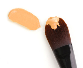 Cosmetic liquid foundation and brush isolated on white