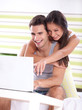 © luckybusiness - Young couple in bedroom using laptop