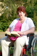Frau im Rollstuhl liest Buch