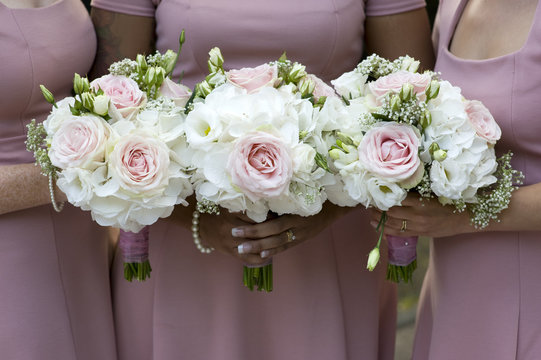 three bridesmaids holding wedding bouquet