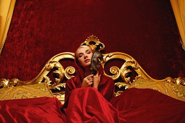 Wall Mural - Beautiful woman with a carnival mask sitting in bed