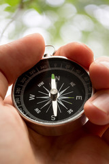 Wall Mural - Hand holding silver black compass