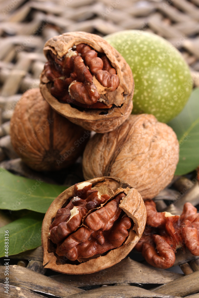 walnuts with green leaves, on  wicker background